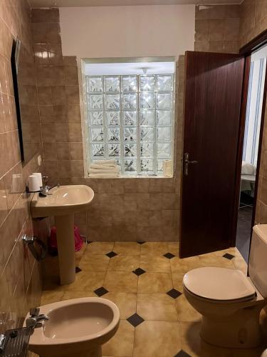 a bathroom with a sink and a toilet and a window at Hostal Terraza Miramar SL in Boiro