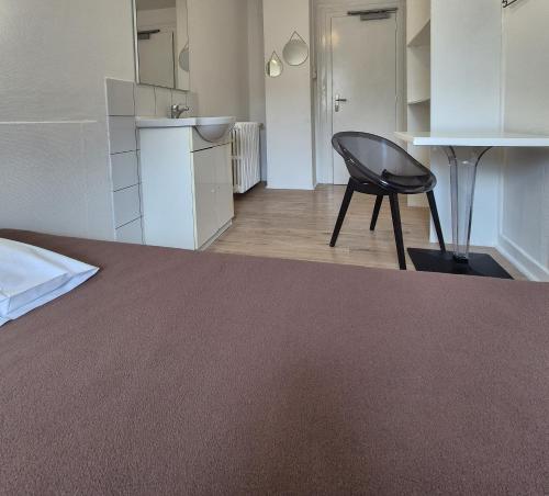 a room with a bed and a chair in it at Budget Hôtel Weber - Strasbourg Centre Gare in Strasbourg