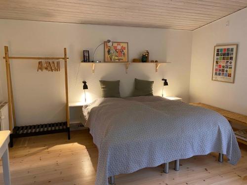 a bedroom with a large bed and two lamps at Idyllically Situated Wooden House By The Forest in Viborg
