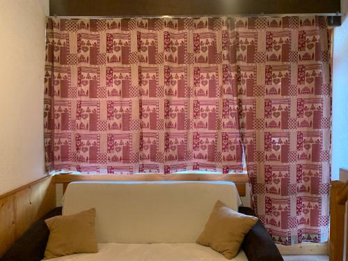 - un salon avec un canapé et un rideau rose dans l'établissement Appartement pour 6 personnes au pied des pistes au calme aux Menuires les Asters, aux Menuires