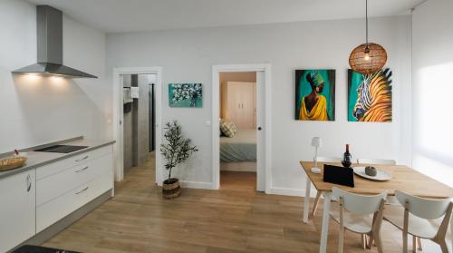 a kitchen and dining room with a table and chairs at Apartamentos LUXURY SUITES MACABEO in Almendralejo