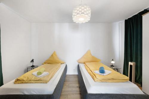 two beds in a small room with green curtains at Bergblick Apartments in Radolfzell am Bodensee