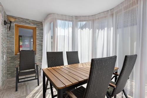 a dining room with a wooden table and chairs at Bergblick Apartments in Radolfzell am Bodensee