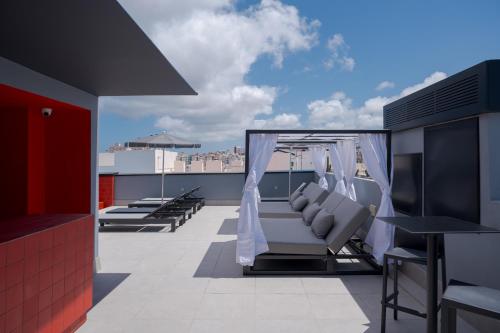 a balcony with a couch and chairs on a roof at Hotel LIVVO La Escarlata in Las Palmas de Gran Canaria