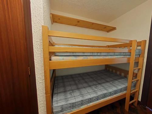 un lit superposé en bois dans une petite pièce dans l'établissement Studio pied des pistes – 4 pers, balcon sud, casier à ski, parking - FR-1-241-126, au Grand-Bornand