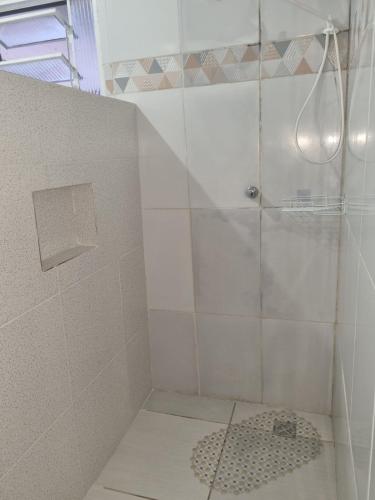 a shower with a glass door in a bathroom at Pousada Flat do Igor com Ar Condicionado Perto da Basílica de Aparecida com 1 vaga Gratuita no Estacionamento in Aparecida