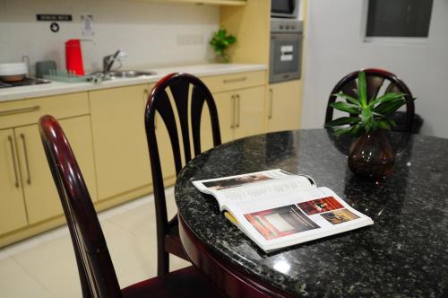 a kitchen with a table with a magazine on it at GRAYHAUS BU4 5BR House - Bandar Utama, near 1 Utama - Stay Only NO EVENTS in Petaling Jaya