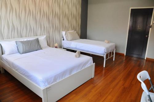 two beds in a room with wooden floors at GRAYHAUS BU4 5BR House - Bandar Utama, near 1 Utama - Stay Only NO EVENTS in Petaling Jaya