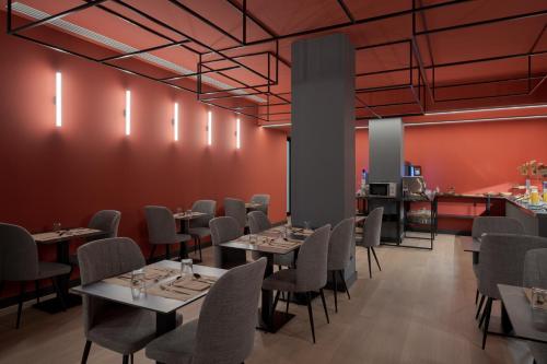 a dining room with tables and chairs and red walls at Hotel LIVVO La Escarlata in Las Palmas de Gran Canaria