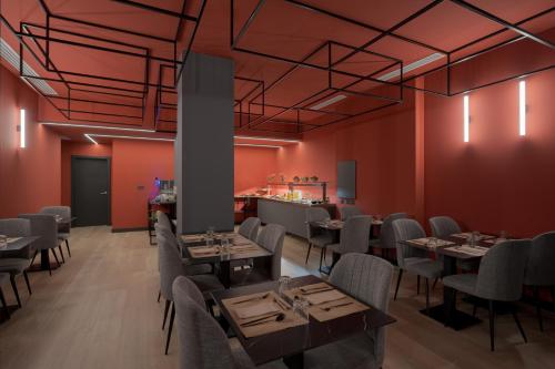 a restaurant with red walls and tables and chairs at Hotel LIVVO La Escarlata in Las Palmas de Gran Canaria