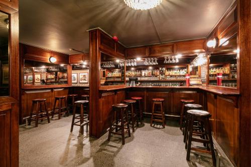 a bar with wooden bar stools in a room at Hotel 224 & Apartments in Pretoria