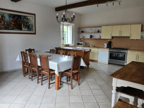 une grande cuisine avec une table et des chaises. dans l'établissement Freslonnière, à Val Couesnon
