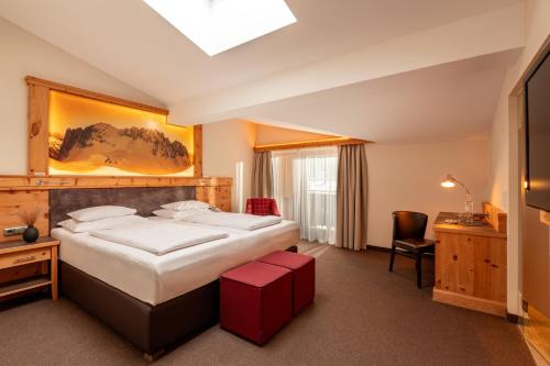 a hotel room with a bed and a desk at Hotel Elisabeth, 4 Sterne Superior in Kirchberg in Tirol