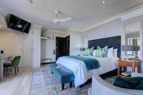a bedroom with a large bed and a tv at African Oceans Manor on the Beach in Mossel Bay