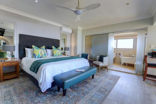a large bedroom with a large bed and a bathroom at African Oceans Manor on the Beach in Mossel Bay