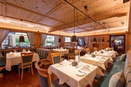 a dining room with white tables and chairs at Hotel Elisabeth, 4 Sterne Superior in Kirchberg in Tirol