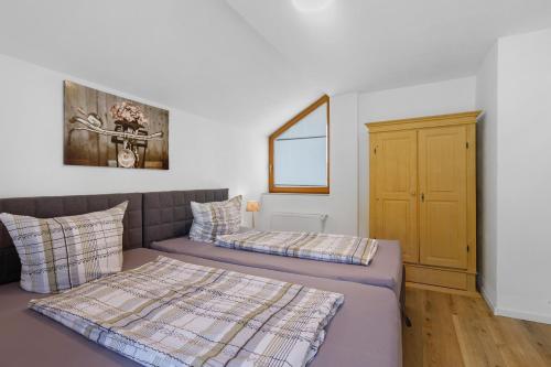 a bedroom with two beds and a cabinet at Bergblick Apartments in Radolfzell am Bodensee