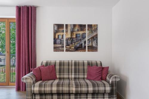 a couch in a living room with a painting on the wall at Bergblick Apartments in Radolfzell am Bodensee