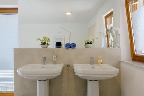 a bathroom with two sinks and a mirror at Bergblick Apartments in Radolfzell am Bodensee