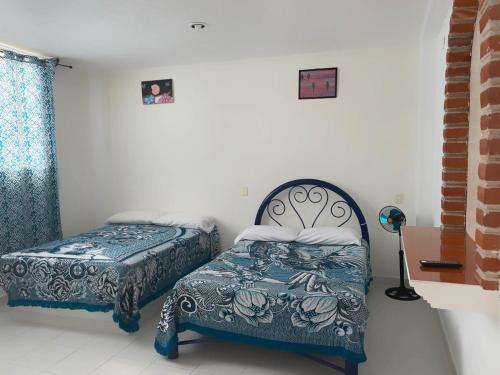 a bedroom with a bed and a bed and a window at Bix Hospedaje Familiar in El Tepé