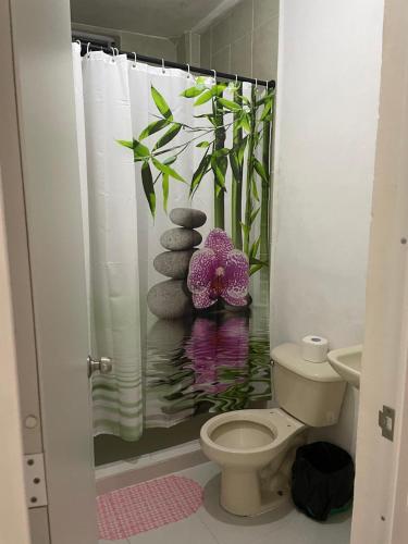 a bathroom with a shower curtain and a toilet at Bix Hospedaje Familiar in El Tepé