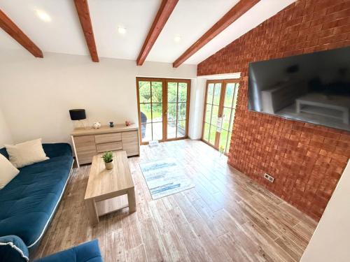 a living room with a blue couch and a brick wall at Horský dům pod přehradou u sjezdovky a potůčka v horách in Český Jiřetín