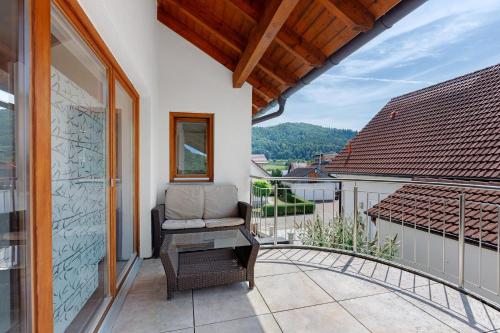 a balcony with a chair and a table at Bergblick Apartments in Radolfzell am Bodensee