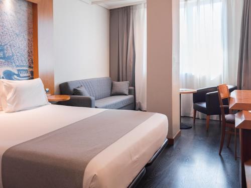 a hotel room with a bed and a couch and a chair at Abba Sants in Barcelona