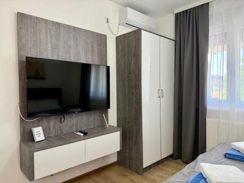 a bedroom with a flat screen tv on a wall at Royal Apartmani 3 in Paraćin
