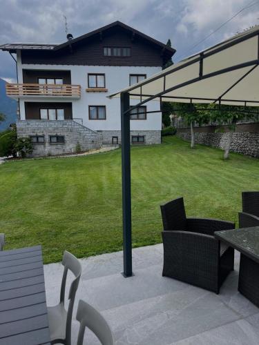 a patio with a table and chairs and a building at Mountain Garden Apartments Abete in Giustino