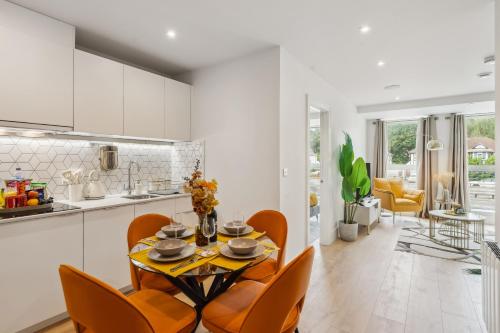 a kitchen and dining room with a table and chairs at Apartment in Wimbledon with Cinema, Gym, Game Room! Upto 30 Percent OFF in New Malden