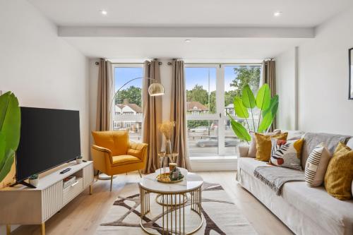 a living room with a couch and a tv at Apartment in Wimbledon with Cinema, Gym, Game Room! Upto 30 Percent OFF in New Malden