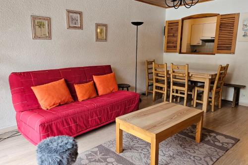 un salon avec un canapé rouge et une table dans l'établissement Apartment with balcony just next to ski slope, à La Salle Les Alpes