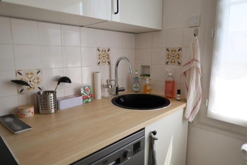 a kitchen with a sink and a counter top at Douce escale - Climatisation in Marzy