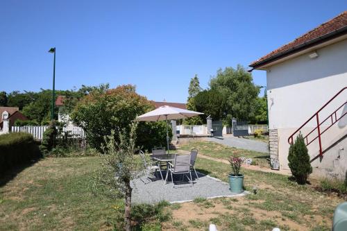 a patio with a table and an umbrella at Douce escale - Climatisation in Marzy