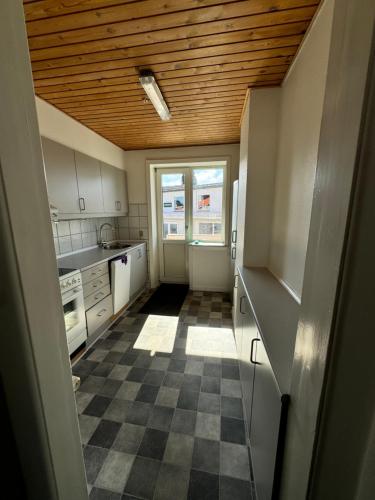a kitchen with a wooden ceiling and a checkered floor at Strandby Kirkevej 270 Ground floor id 021 in Esbjerg