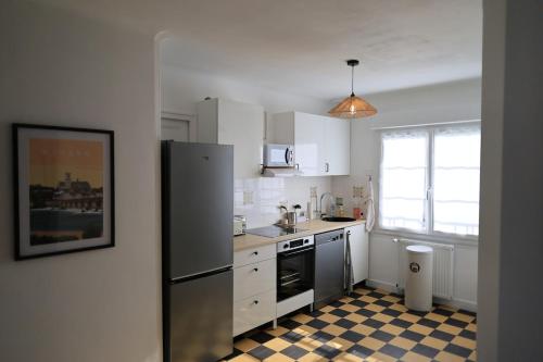 a kitchen with a stainless steel refrigerator and a checkered floor at Douce escale - Climatisation in Marzy