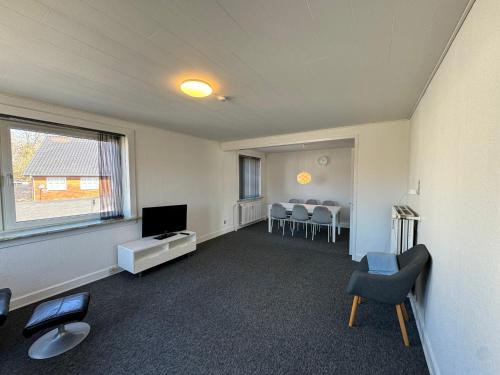 a living room with a tv and a table and chairs at Strandby Kirkevej 270 Ground floor id 021 in Esbjerg