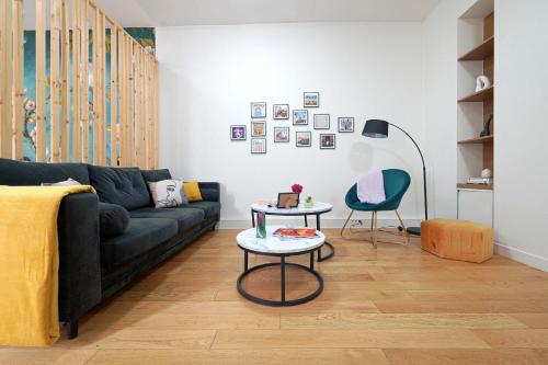 un salon avec un canapé noir et une table dans l'établissement Fresh large studio for 4, à Paris
