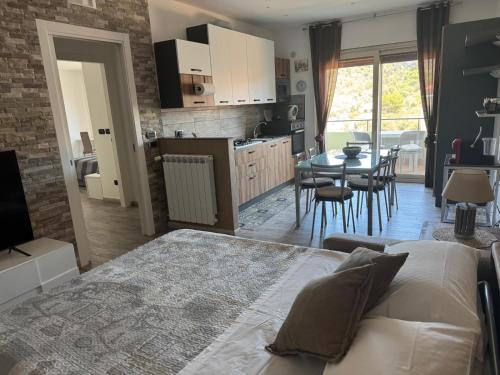 Un dormitorio con una cama y una cocina con una mesa. en Luxury Green Apartment, en Milazzo