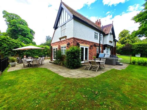 a house with a patio with tables and chairs at Bridgegate in Belper