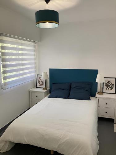 une chambre avec un grand lit avec une tête de lit bleue dans l'établissement Superbe Appartement 2p avec place de parking, à Antibes