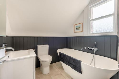 a bathroom with a tub and a toilet and a sink at 4 Bed in Swanage oc-a29454 in Swanage