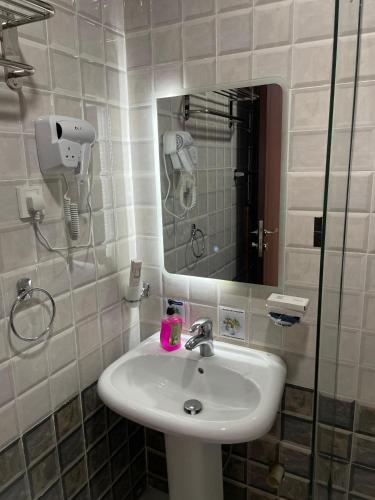 a bathroom with a sink and a mirror at فندق شركة صلاح المدينة in Az Zāhir