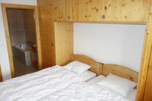a bedroom with a bed and a bathroom with a tub at Plein Ciel VA 032 - MOUNTAIN apartment 6 pers in Veysonnaz