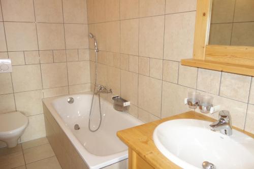 a bathroom with a tub and a sink and a toilet at Plein Ciel VA 032 - MOUNTAIN apartment 6 pers in Veysonnaz