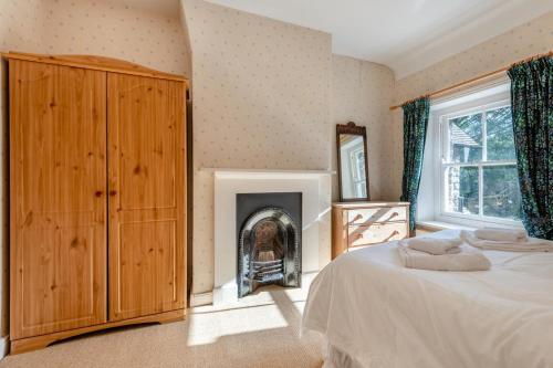 een slaapkamer met een bed en een open haard bij Stone Cottage - Swanage in Swanage