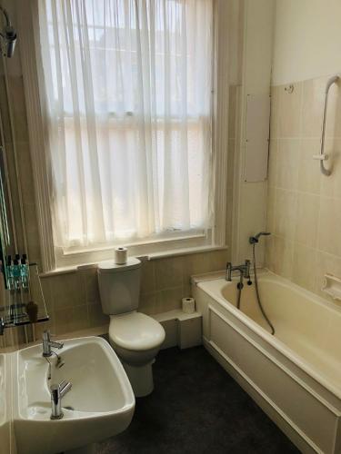 a bathroom with a sink and a toilet and a bath tub at Albany, Brighton & Hove in Brighton & Hove