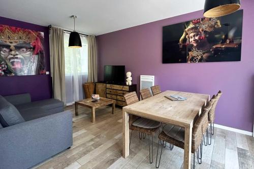 a dining room with purple walls and a table and chairs at Villa Indonésie - Domaine Le Sherwood in Notre-Dame-de-Monts