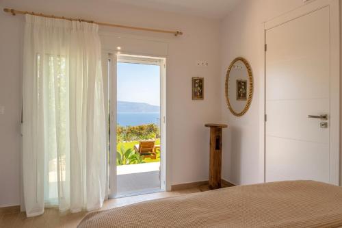 a bedroom with a bed and a sliding glass door at Jacob's Place Kalamos in Kalamos